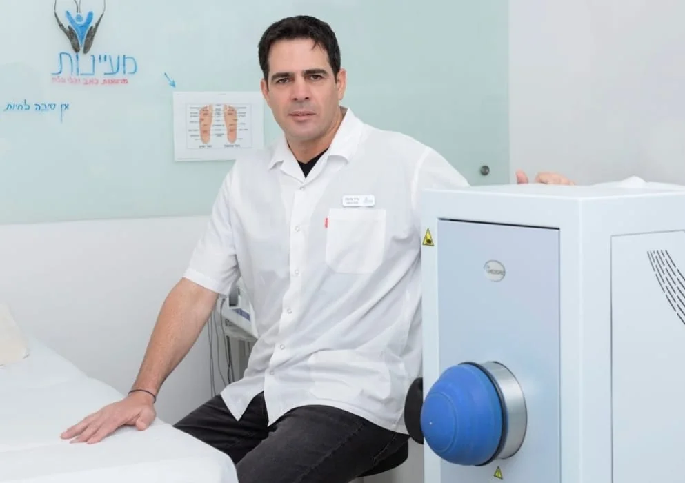 אייל אלימלך בקליניקת מעיינות לצד מכשיר גלי הלם