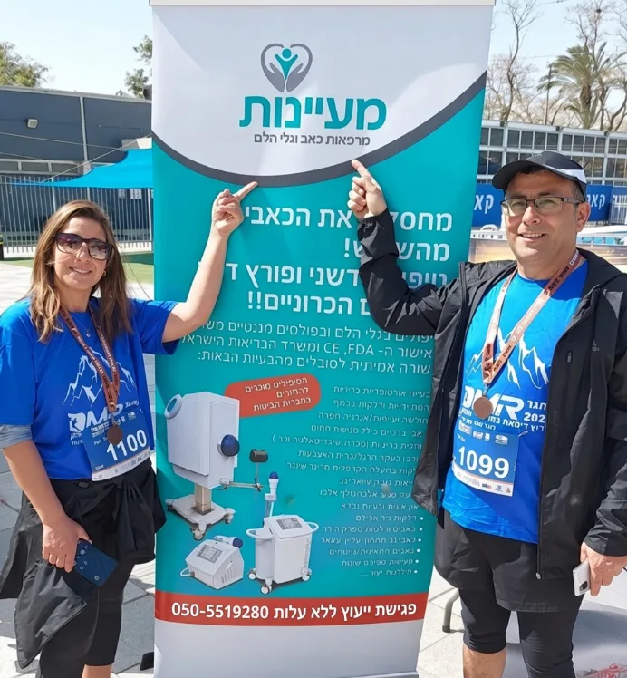 שני רצים עם מדליות מצביעים על שלט מעיינות באירוע ריצה